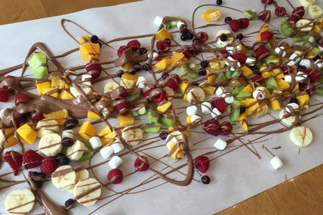 Fondue au chocolat avec des fruits sur une table