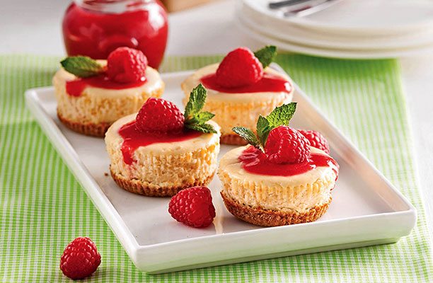 Mini gâteaux au fromage avec coulis de framboises pour servir comme dessert à Noël