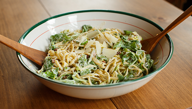 Plat de pâtes : linguines à la crème sure et à la roquette avec des poireaux tranchés