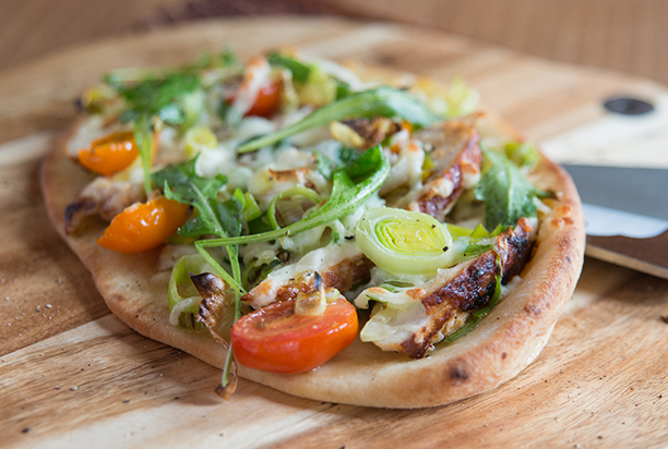 Recette de pizza au poulet avec des poireaux tranchés, lavés et prêts à cuire et de la roquette