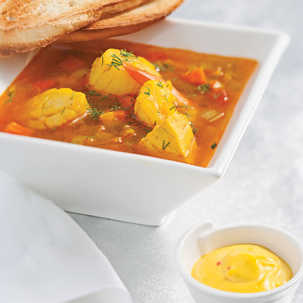 Soupe de poisson méditerranéenne avec des crevettes, des pétoncles, des poireaux, du safran et des légumes