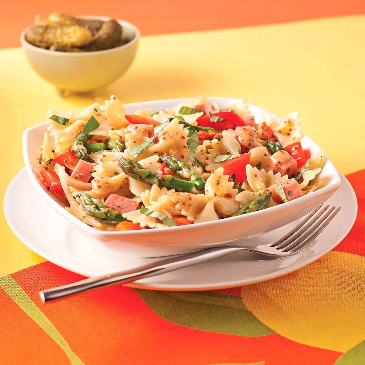 Ham farfalle warm salad with sun-dried tomatoes and asparagus